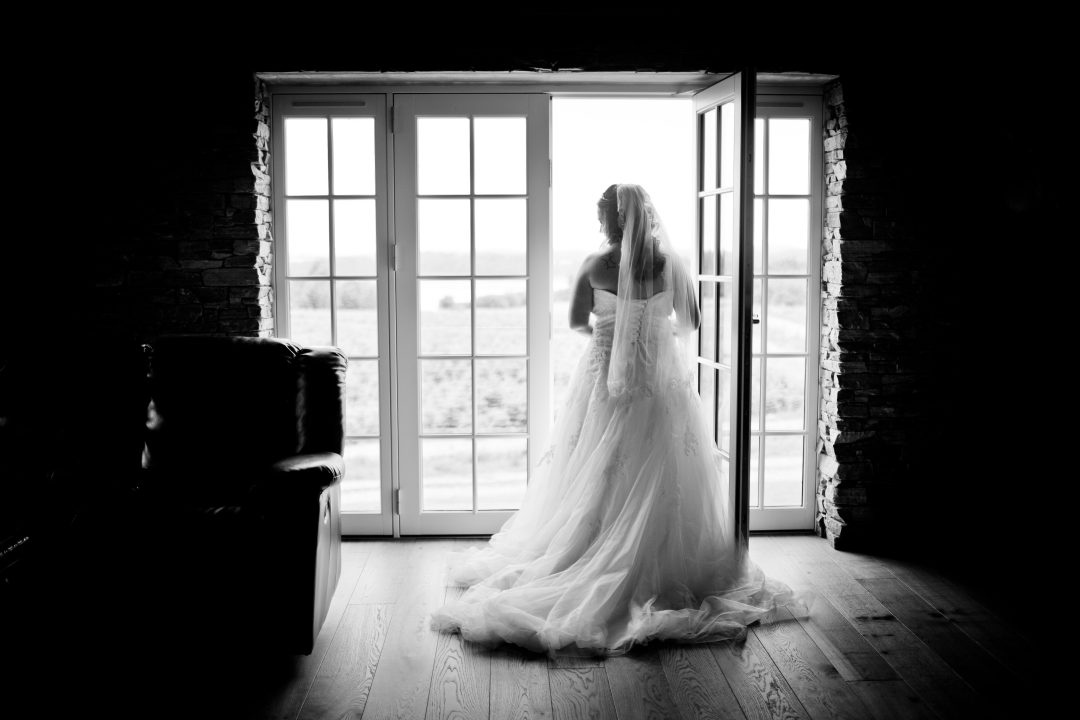 Why hire wedding planners: A black-and-white photo of a bride facing the door.