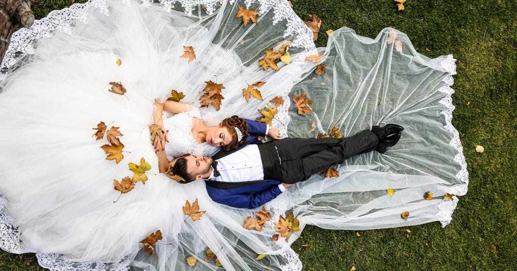 Bride and groom lying down in park