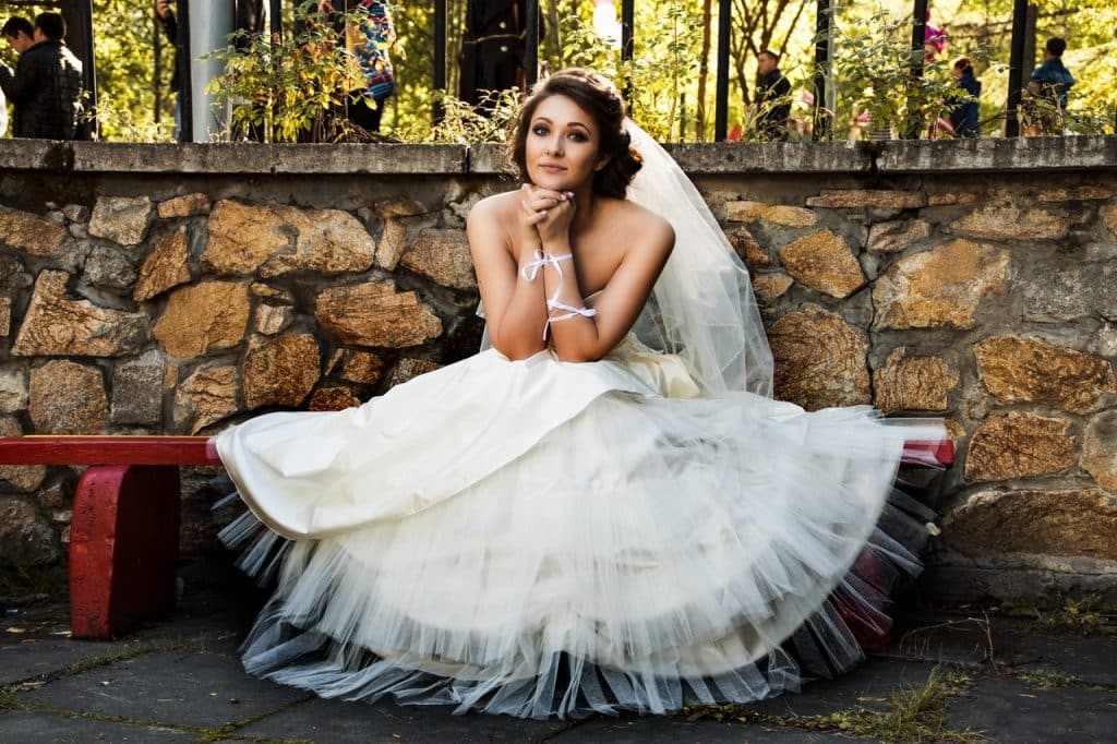 Bride White wedding dress sitting outside thinking why consider wedding planner or coordinator