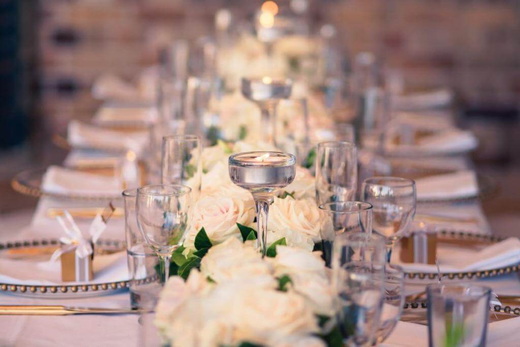 Wedding Styling White Flowers with Glass Candles and Gold Charger Plates