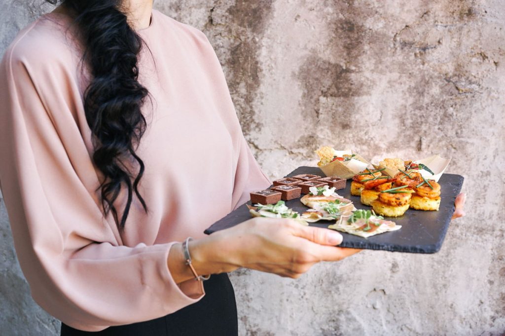 A photo of an event planner holding a canape tray service