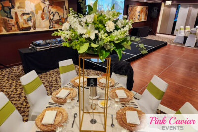 Tall Articicial White Flowers and Greenery on Gold Stand with Gold Flare Charger Plates with White and Willow Green Chairs