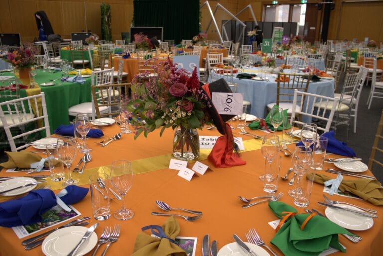 Styled mis-matched tables - orange with mad hatter hat and flowers
